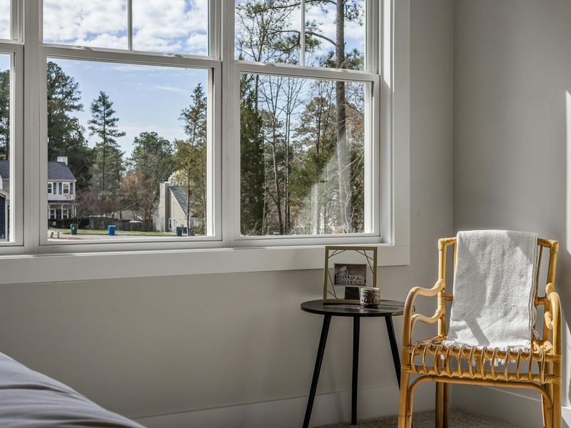 A bright and airy room with a comfortable chair near a large window.